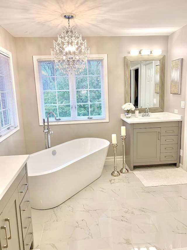 bathroom with vanity, a bath, and a notable chandelier