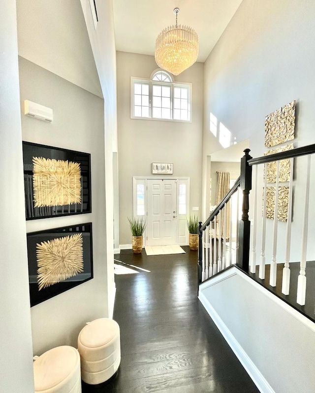 entrance foyer featuring a high ceiling, a notable chandelier, and dark hardwood / wood-style flooring