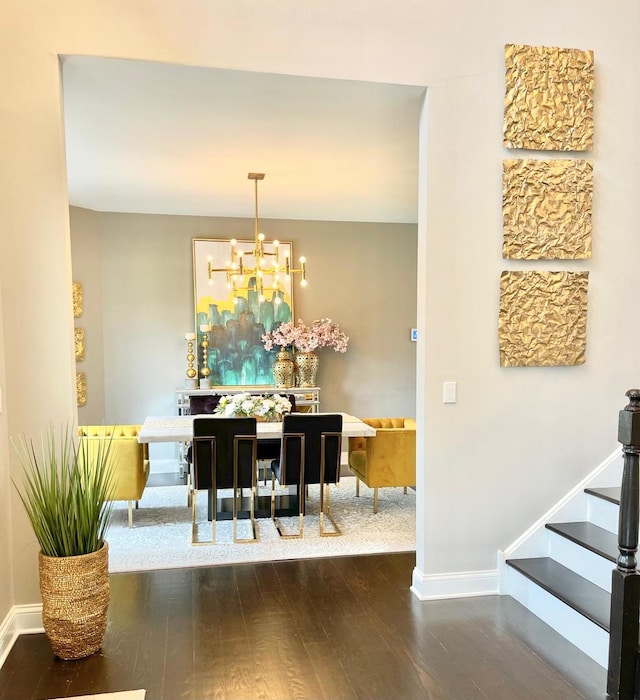 dining area featuring dark wood-type flooring and a chandelier