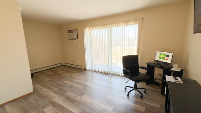 home office featuring a baseboard heating unit, light hardwood / wood-style floors, and an AC wall unit