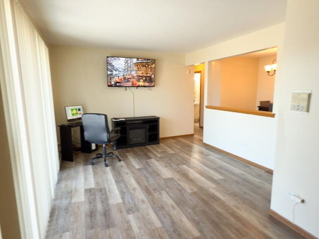 home office with baseboards and wood finished floors