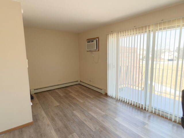 bedroom featuring baseboard heating and wood-type flooring