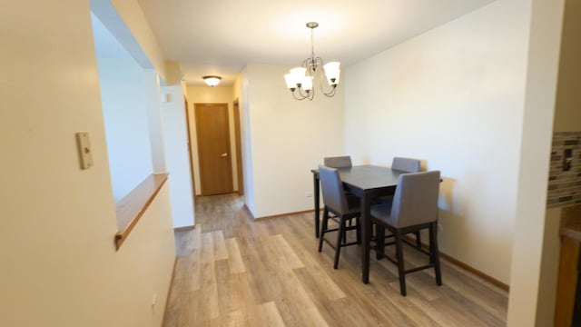 dining room with a notable chandelier and light hardwood / wood-style flooring