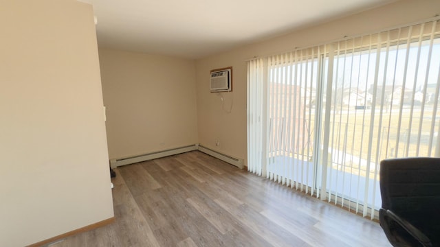 empty room featuring light wood-type flooring and a wall unit AC