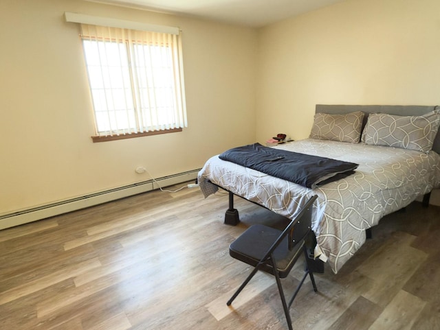 bedroom featuring a baseboard radiator and wood finished floors