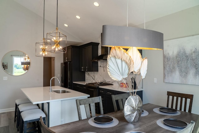 dining space featuring vaulted ceiling, sink, and hardwood / wood-style floors