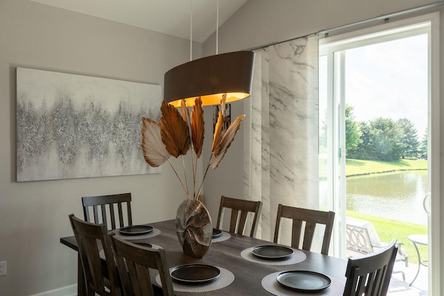 dining space featuring a water view and lofted ceiling