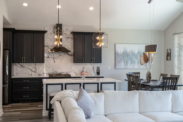 kitchen with sink, extractor fan, decorative backsplash, dark hardwood / wood-style flooring, and decorative light fixtures