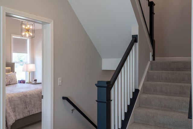 stairs with an inviting chandelier and carpet