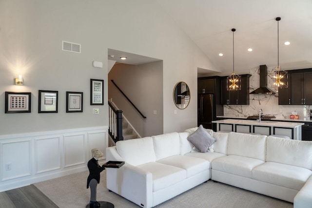 living room featuring high vaulted ceiling and light hardwood / wood-style flooring