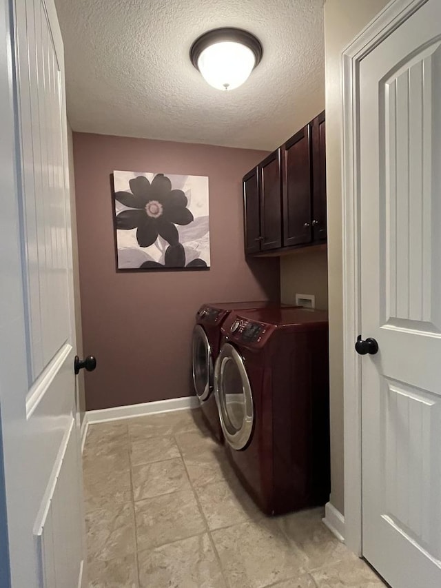 laundry area with cabinets, independent washer and dryer, and a textured ceiling