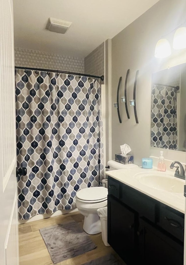 bathroom with vanity, hardwood / wood-style floors, and toilet