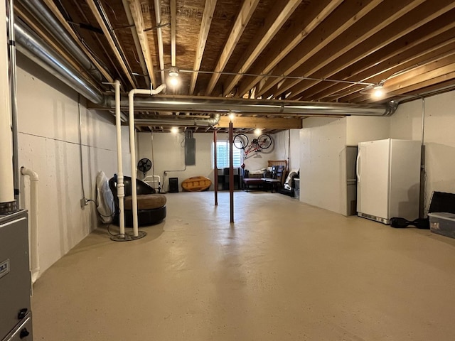 basement featuring white fridge and electric panel