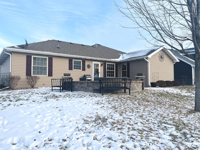 view of snow covered rear of property