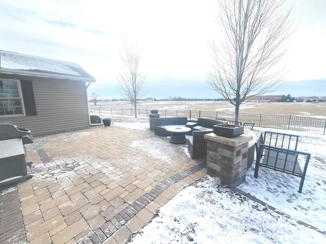 snow covered patio with an outdoor fire pit