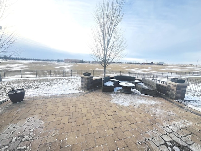 snow covered patio featuring a rural view