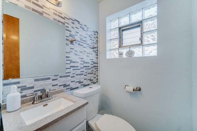 bathroom with vanity, backsplash, and toilet