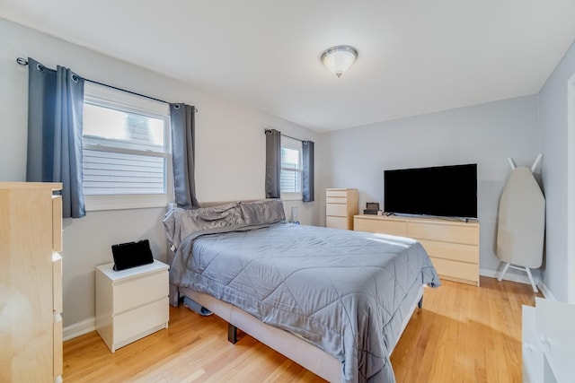 bedroom with multiple windows and wood-type flooring