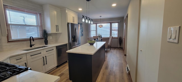 kitchen featuring tasteful backsplash, stainless steel appliances, sink, and a kitchen island