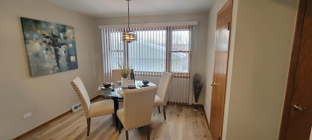 dining space with an inviting chandelier and light hardwood / wood-style floors