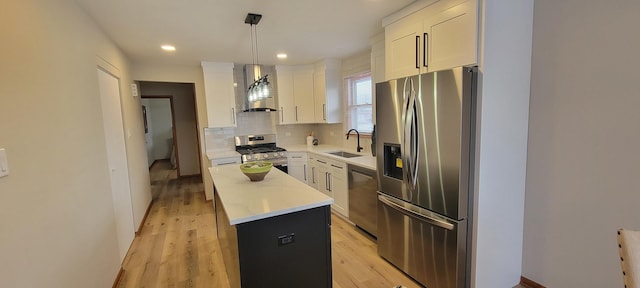 kitchen featuring white cabinetry, stainless steel appliances, decorative light fixtures, and a center island