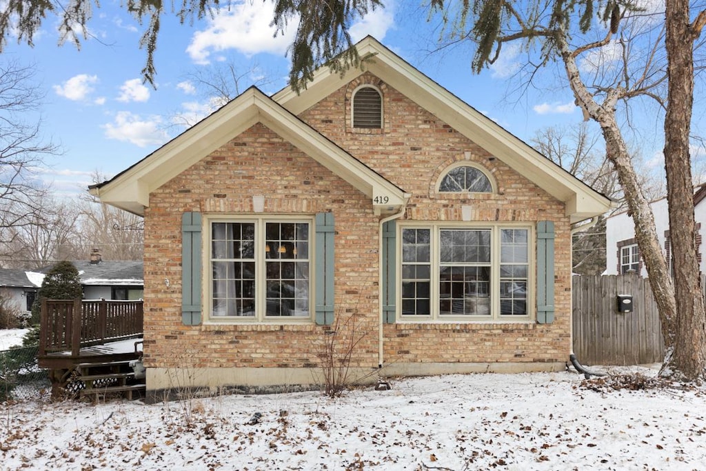 snow covered rear of property featuring a deck