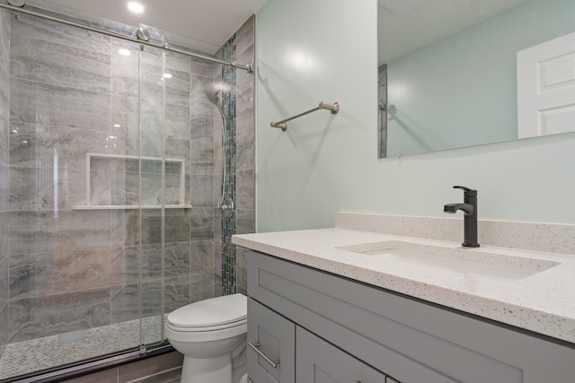 bathroom featuring vanity, walk in shower, and toilet