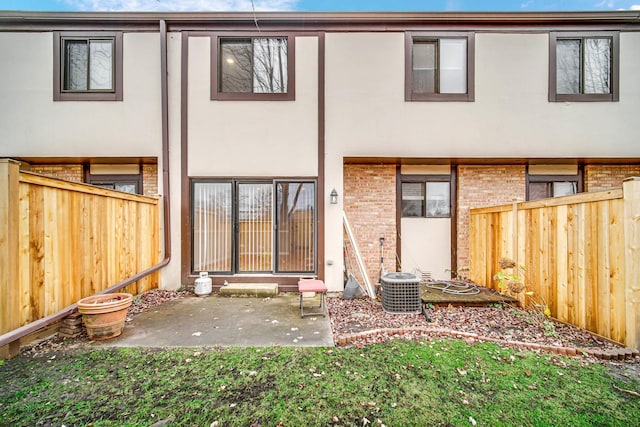 rear view of house featuring cooling unit and a patio