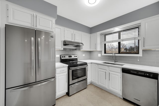 kitchen with tasteful backsplash, sink, white cabinets, light tile patterned floors, and stainless steel appliances