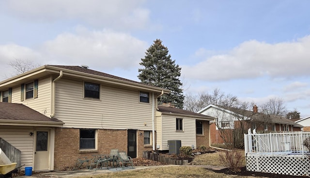 rear view of property with central AC unit and a deck