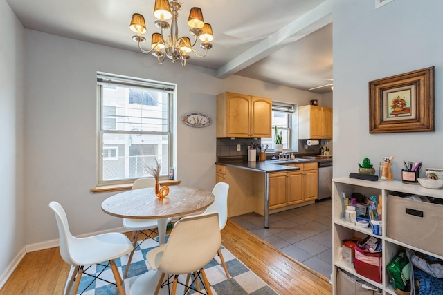 kitchen featuring decorative light fixtures, tasteful backsplash, dishwasher, a notable chandelier, and light wood-type flooring