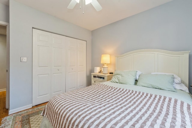 bedroom with light hardwood / wood-style flooring, ceiling fan, and a closet