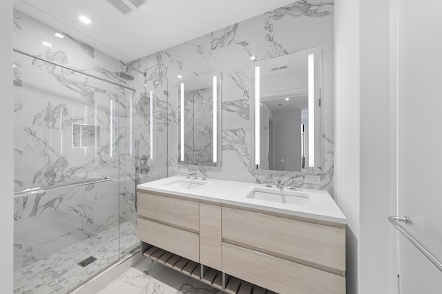 full bathroom featuring a marble finish shower, marble finish floor, stone wall, and a sink