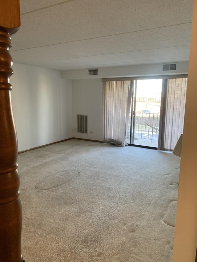 carpeted empty room featuring a textured ceiling