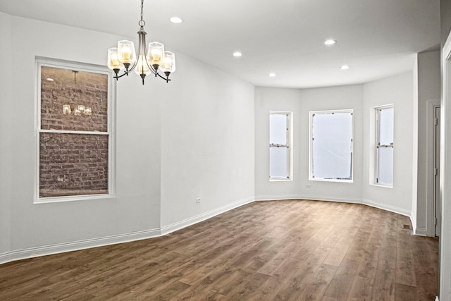 empty room with an inviting chandelier and dark hardwood / wood-style floors