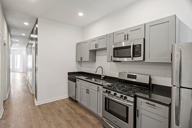 kitchen featuring gray cabinetry, sink, light wood-type flooring, and appliances with stainless steel finishes