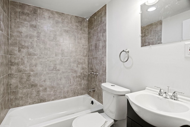 full bathroom with tiled shower / bath, vanity, and toilet