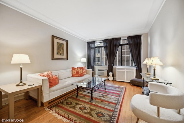 living room featuring ornamental molding, wood-type flooring, and radiator