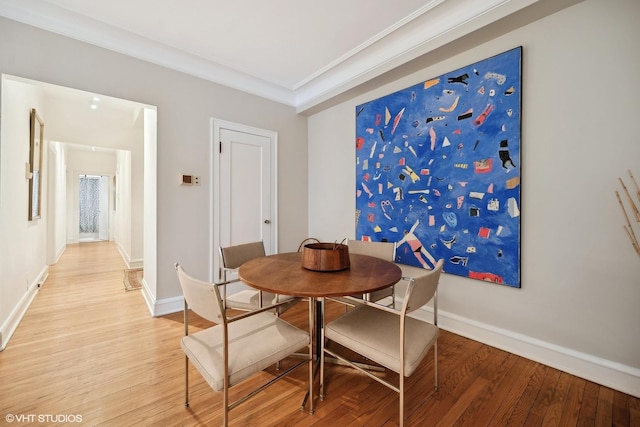 dining room featuring wood-type flooring and crown molding