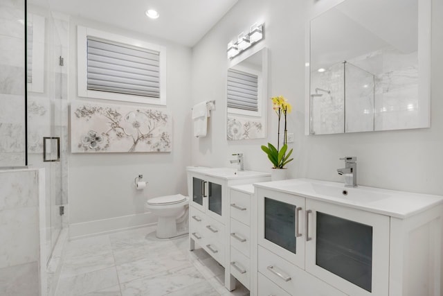 bathroom featuring a shower with door, vanity, and toilet