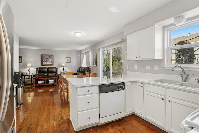 kitchen with sink, stainless steel refrigerator, white dishwasher, white cabinets, and kitchen peninsula