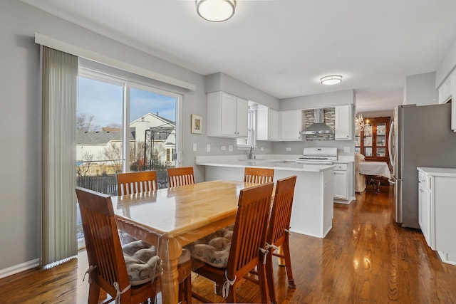 dining space with dark hardwood / wood-style flooring and sink