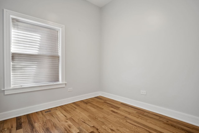 unfurnished room featuring hardwood / wood-style flooring and a healthy amount of sunlight