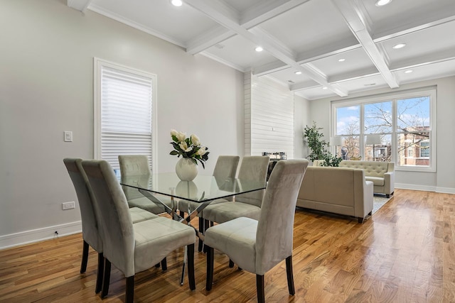 dining area featuring coffered ceiling, beam ceiling, and light hardwood / wood-style flooring