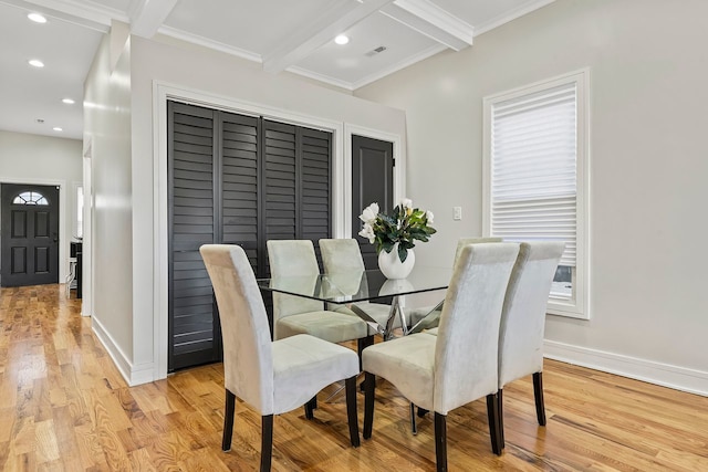 dining space with coffered ceiling, ornamental molding, beam ceiling, and light hardwood / wood-style flooring