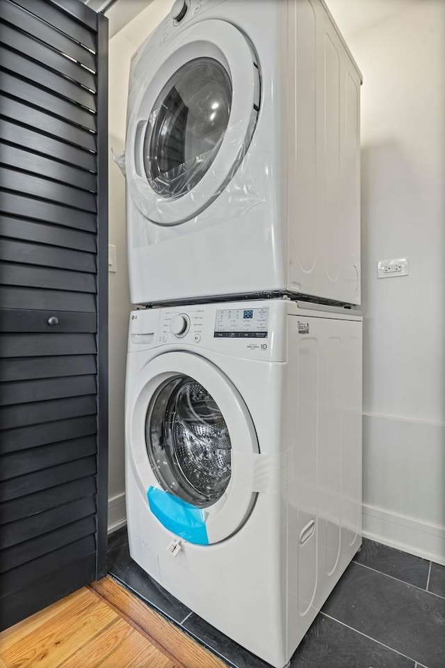 laundry area featuring stacked washer and clothes dryer and tile patterned floors