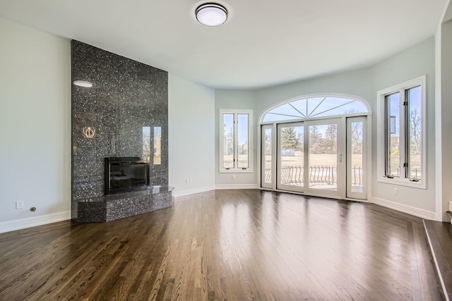 unfurnished living room featuring dark hardwood / wood-style flooring and a high end fireplace