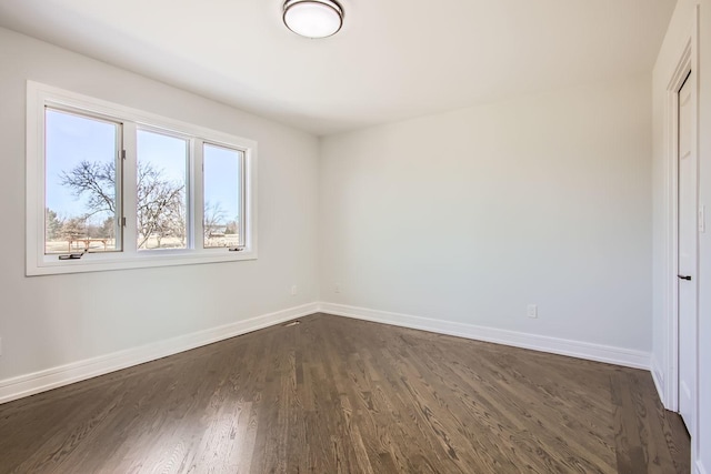 unfurnished room with dark hardwood / wood-style flooring