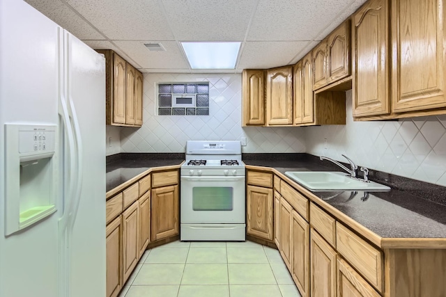 kitchen with light tile patterned flooring, a paneled ceiling, sink, decorative backsplash, and white appliances