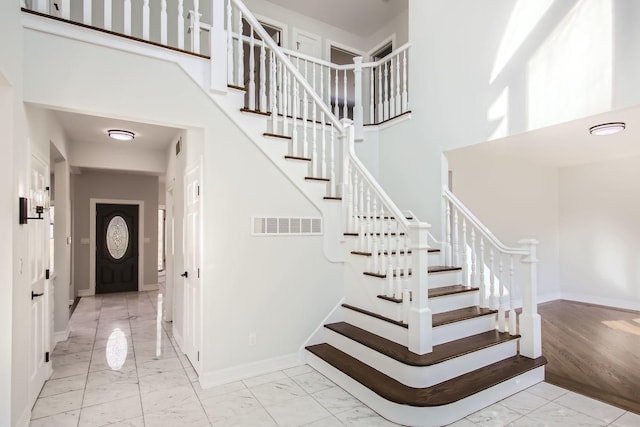 staircase featuring a towering ceiling